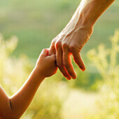 Vater und Kind fassen sich an der Hand